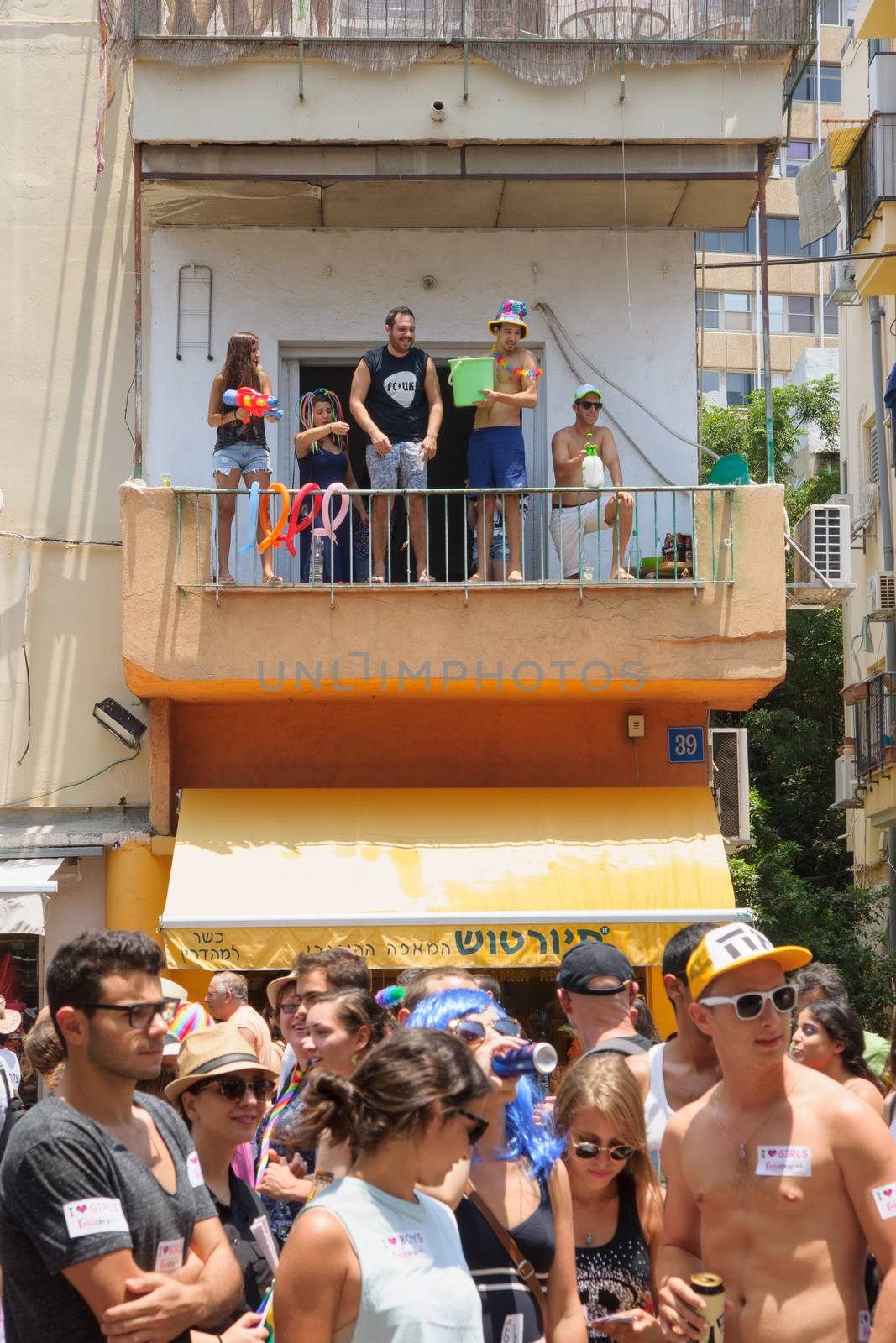 TEL-AVIV - JUNE 13, 2014: Spectator refresh the pride parade participants with cold water. The annual parade in the streets of Tel-Aviv, Israel is held on a hot June day.