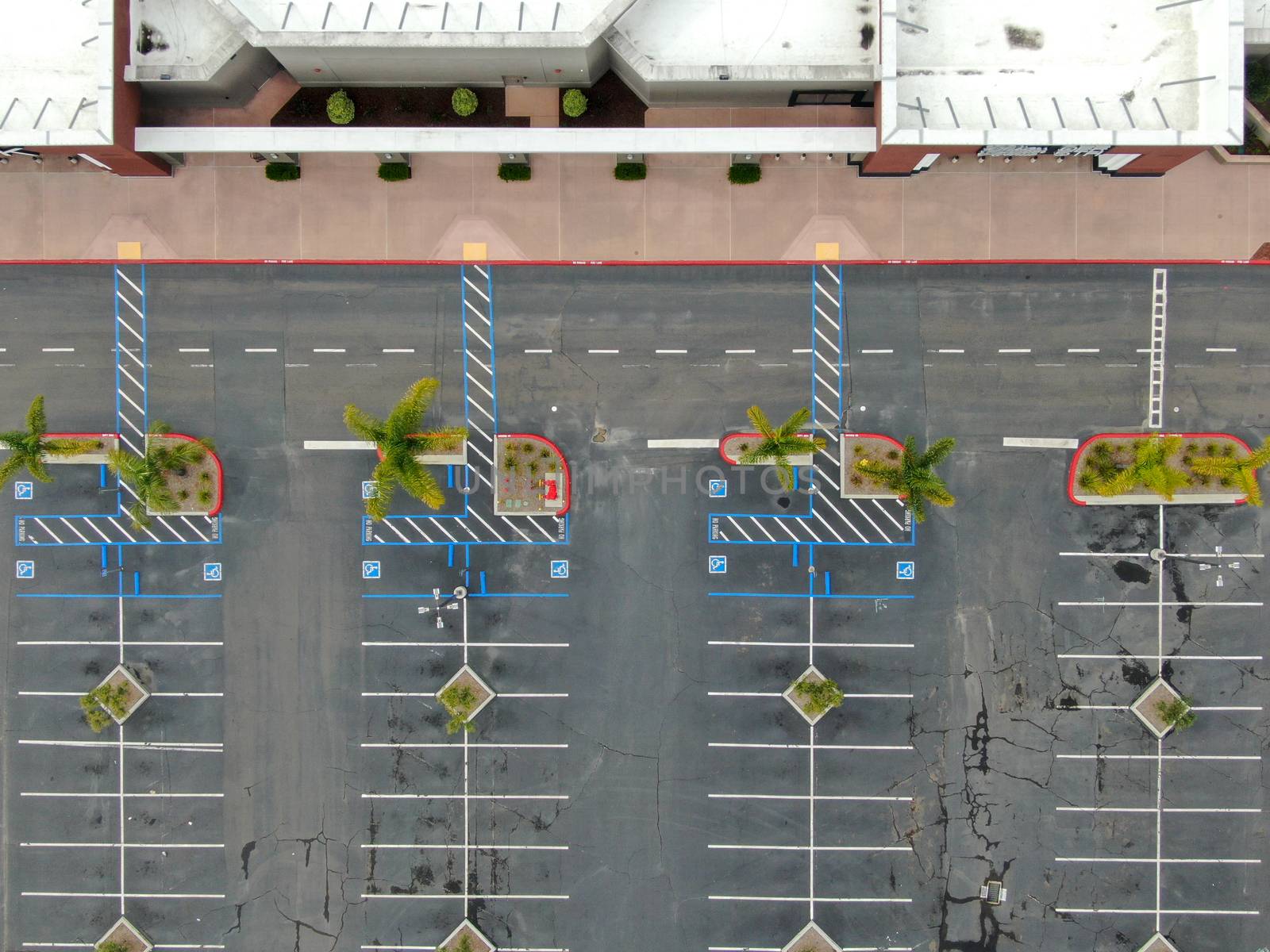 Aerial view of empty shopping center parking lot during COVID-19 pandemic. by Bonandbon