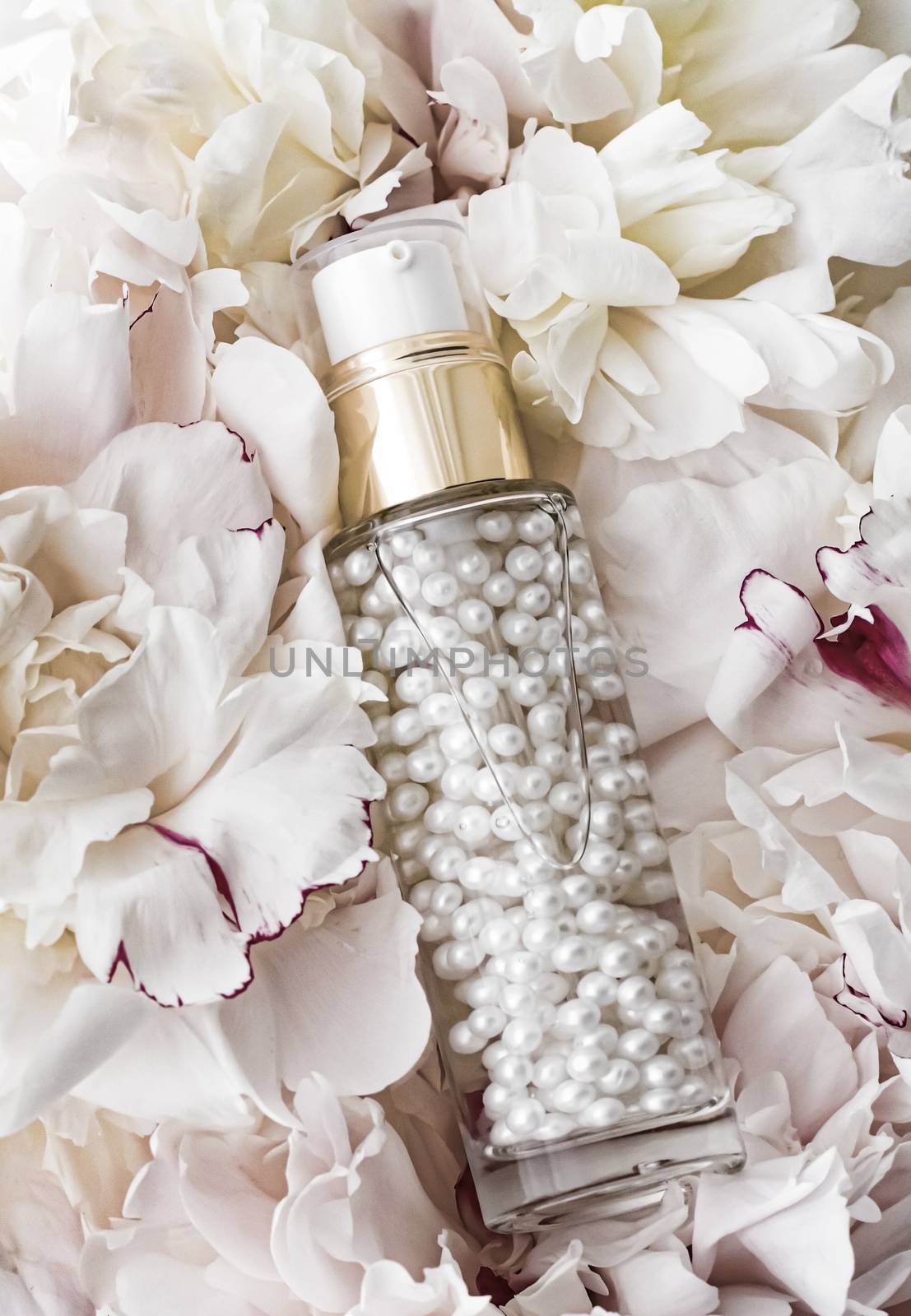 Luxurious cosmetic bottle as antiaging skincare product on background of flowers, blank label packaging for body care branding design