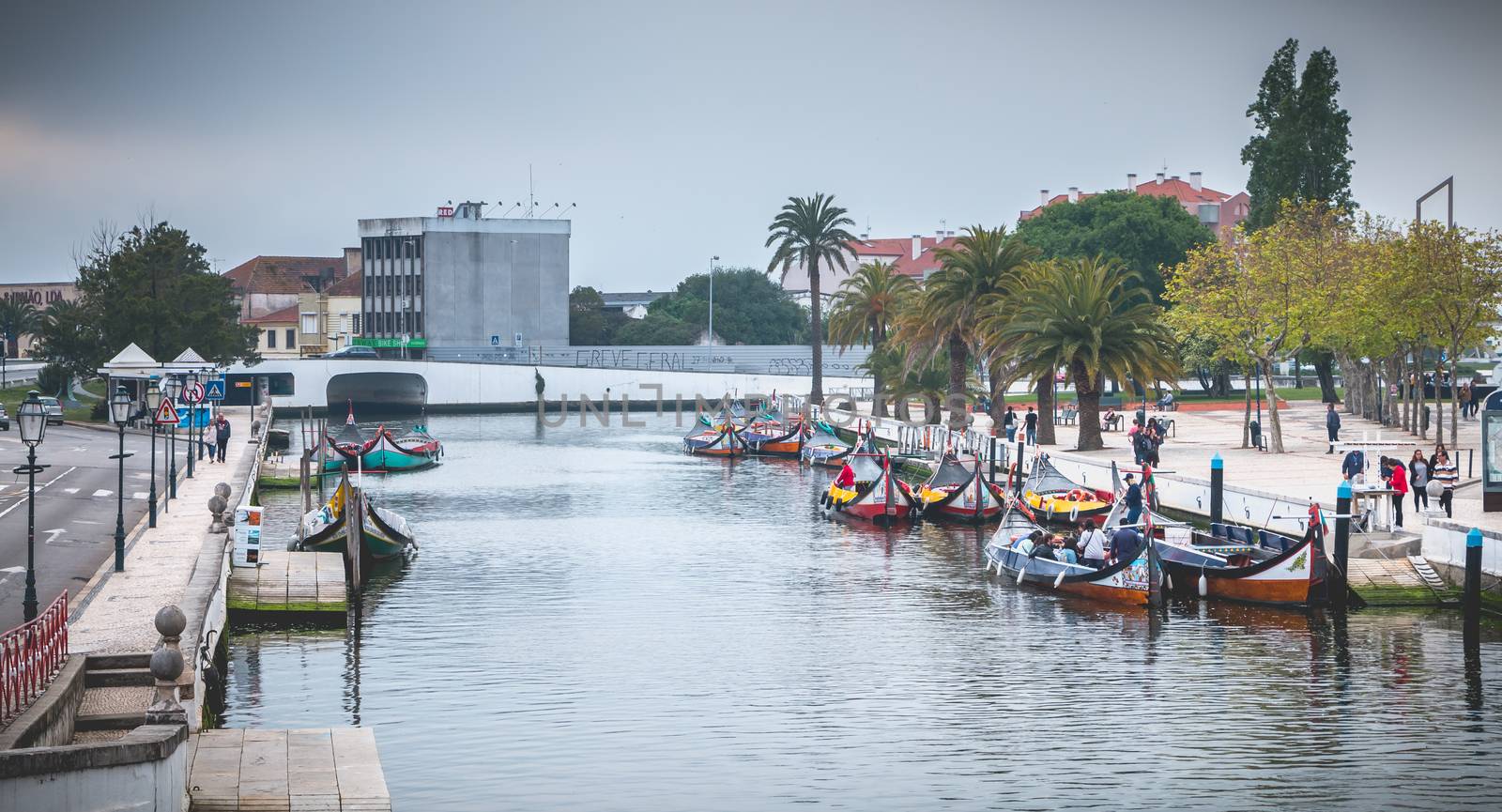 Aveiro, Portugal - May 7, 2018: Tourists walk on famous Moliceiros on a spring evening, traditional boats used to harvest seaweeds in the past