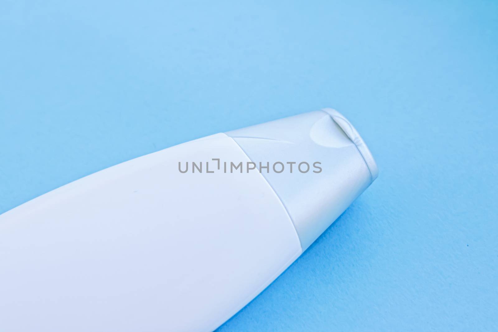 Blank label cosmetic container bottle as product mockup on blue background by Anneleven