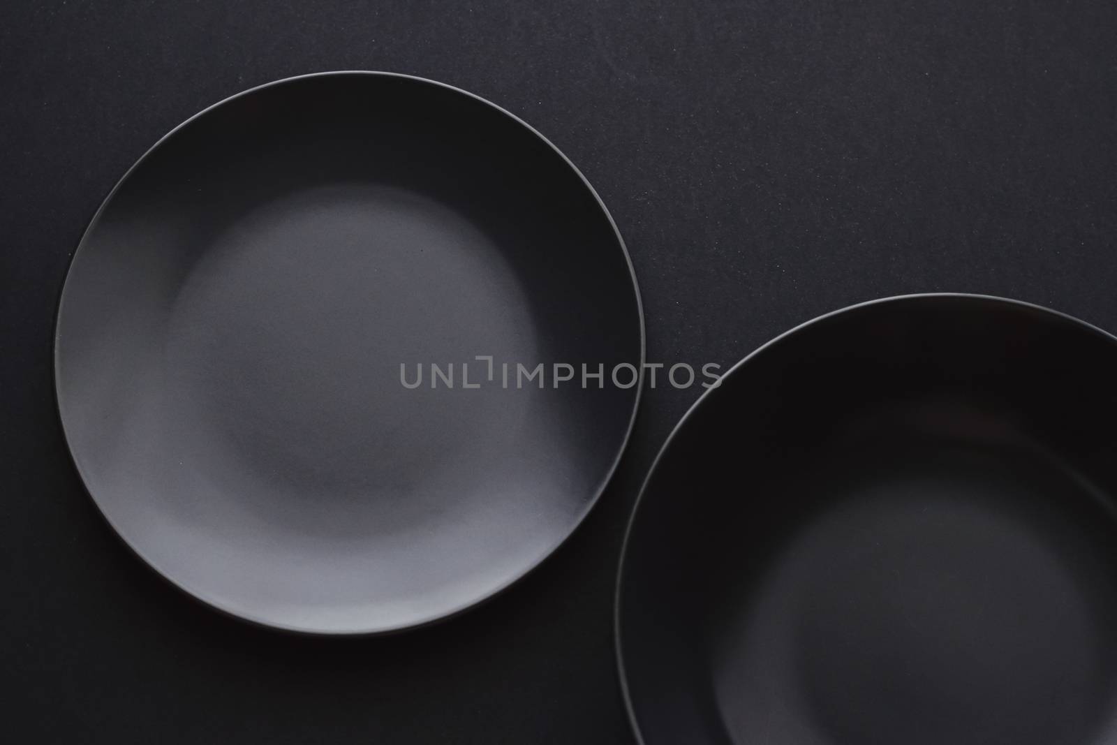 Empty plates on black background, premium dishware for holiday dinner, minimalistic design and diet concept