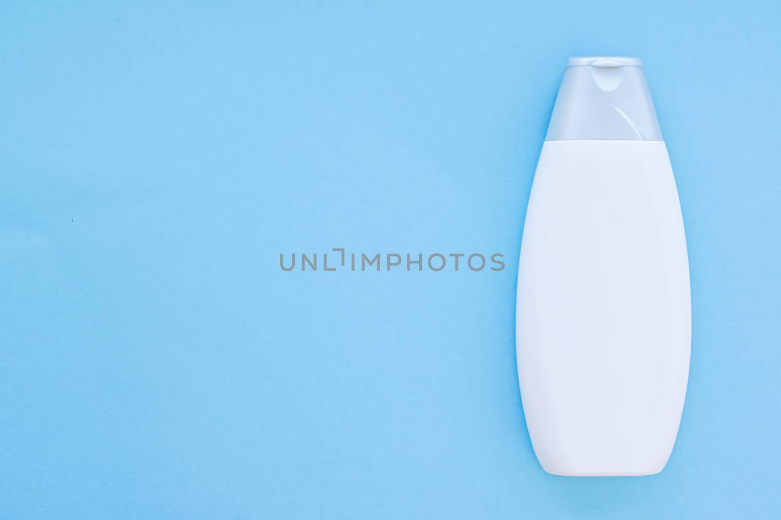 Blank label cosmetic container bottle as product mockup on blue background by Anneleven