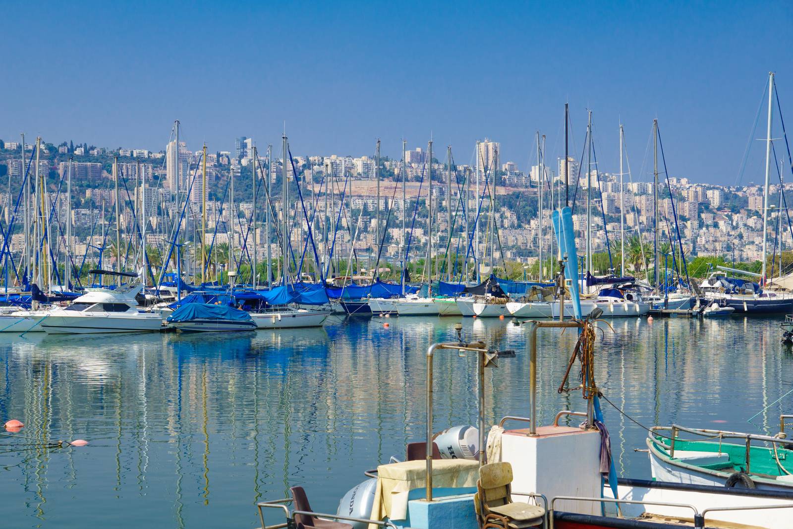HAIFA, ISRAEL - JULY 31, 2015: Yacht at the Shavit Anchorage, part of the Kishon Port, and the city of Haifa in the background. Haifa, Israel