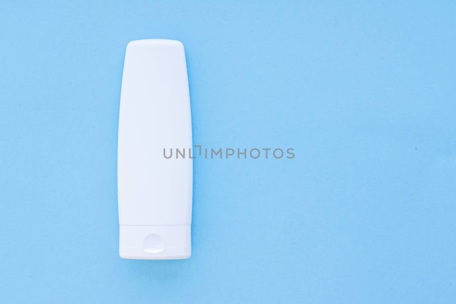 Blank label cosmetic container bottle as product mockup on blue background, hygiene and healthcare