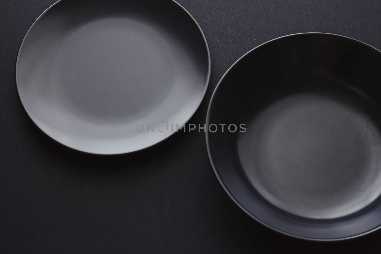 Empty plates on black background, premium dishware for holiday dinner, minimalistic design and diet concept