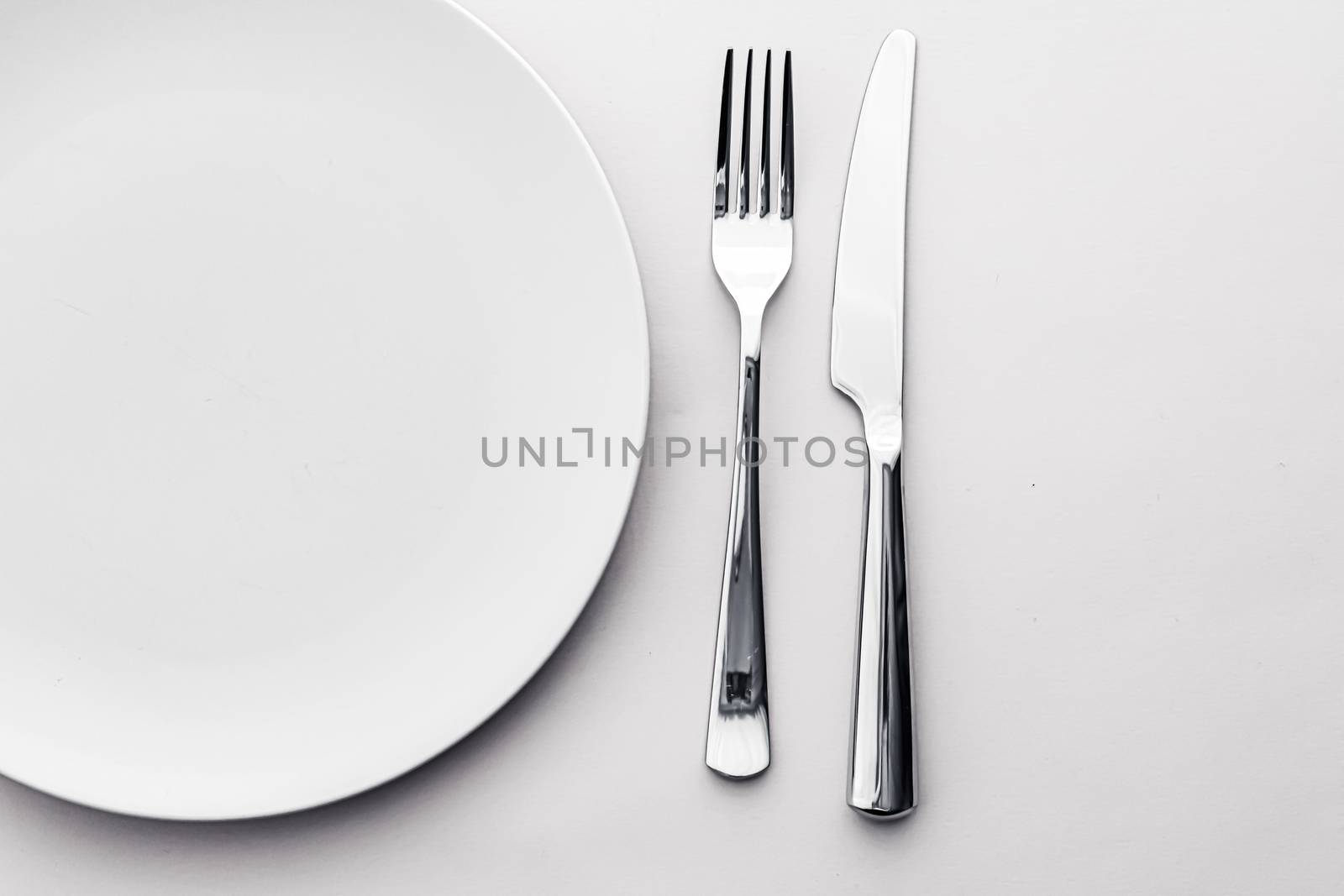 Empty plate and cutlery as mockup set on white background, top tableware for chef table decor and menu branding design