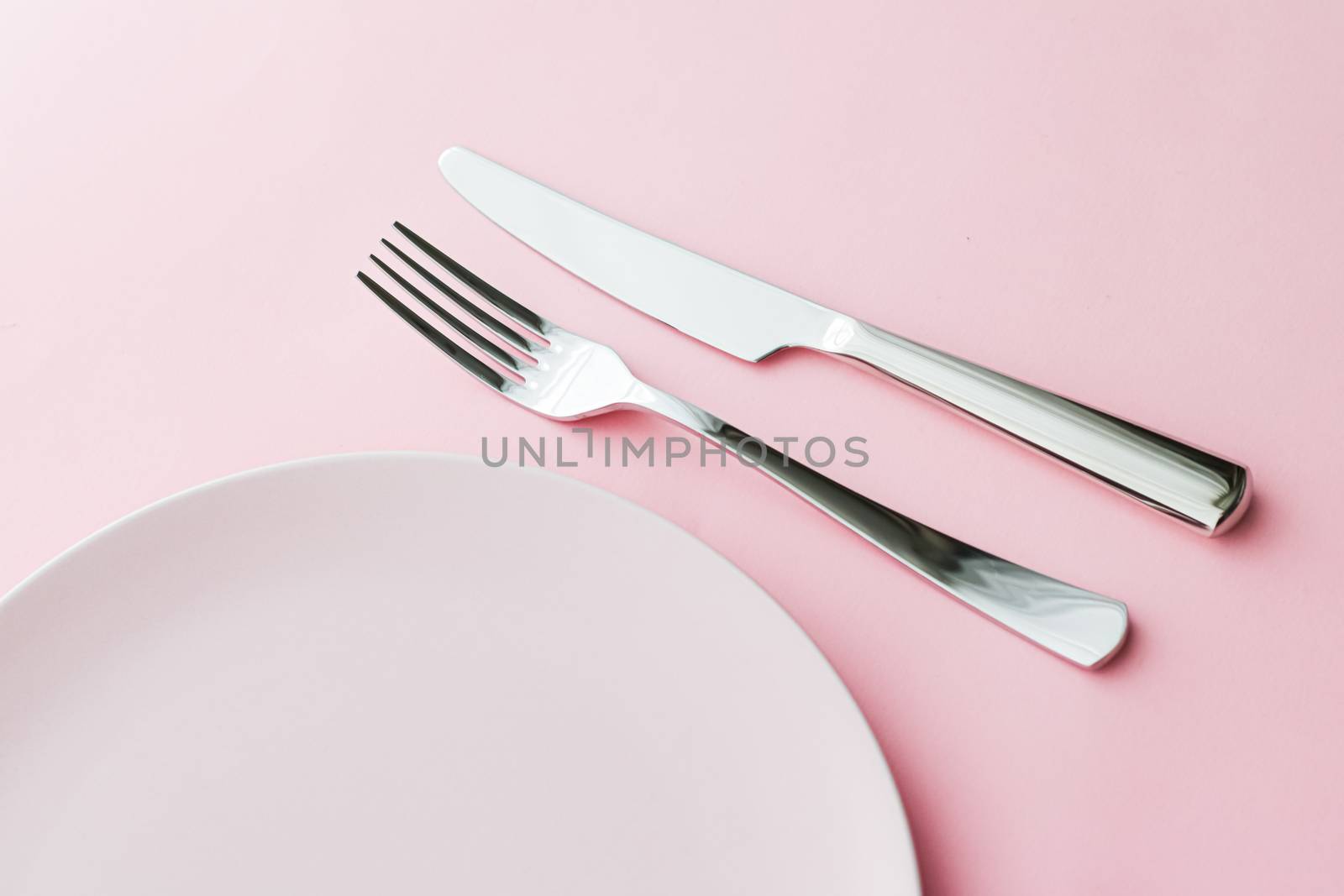 Empty plate and cutlery as mockup set on pink background, top tableware for chef table decor and menu branding by Anneleven