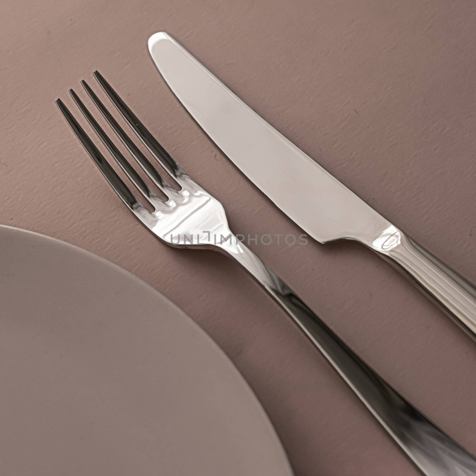 Empty plate and cutlery as mockup set on brown background, top tableware for chef table decor and menu branding design