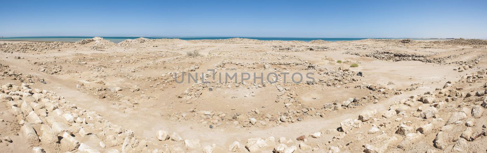 Old roman ruins on desert coastline by paulvinten