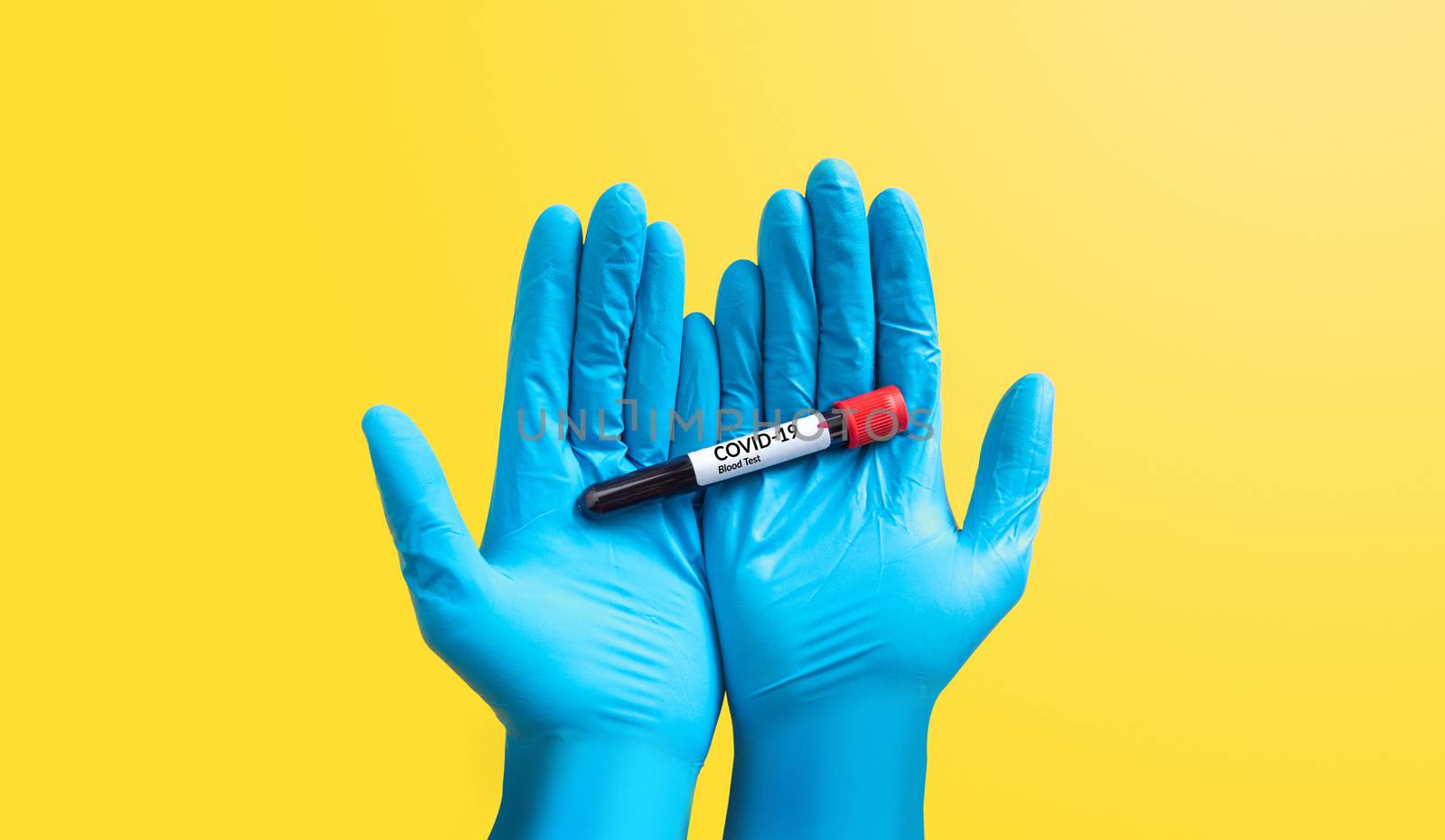closeup hand in blue rubber glove holding Coronavirus blood sample in test tube for covid-19 analyzing, isolated on yellow. laboratory analyzing for testing and invent drug and vaccine for Coronavirus