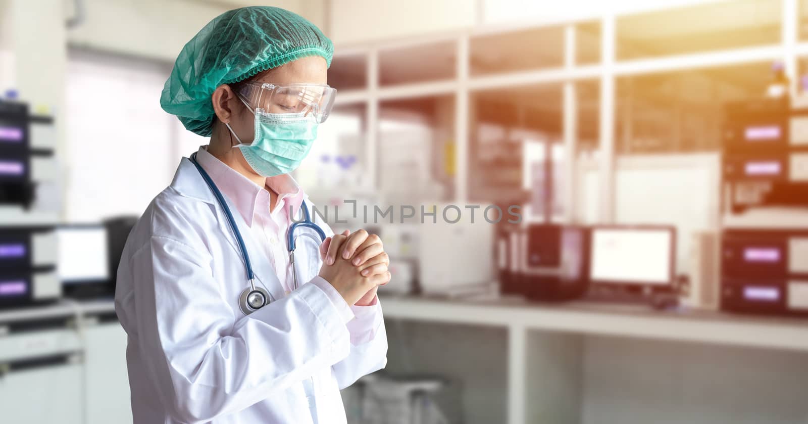 stress Asian doctor in uniform suit, medical mask and cap make a praying in hospital during transmission of Covid-19 coronavirus disease outbreak situation