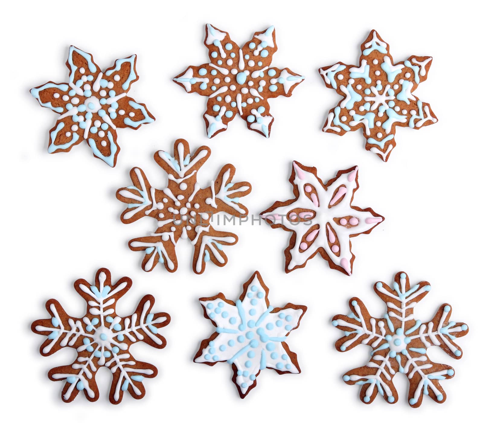 Homemade snowflake shaped gingerbread cookies with sugar icing, on white background isolated
