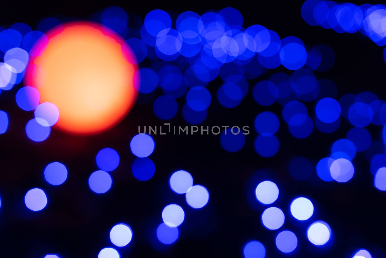 Defocused abstract blue christmas background with orange light