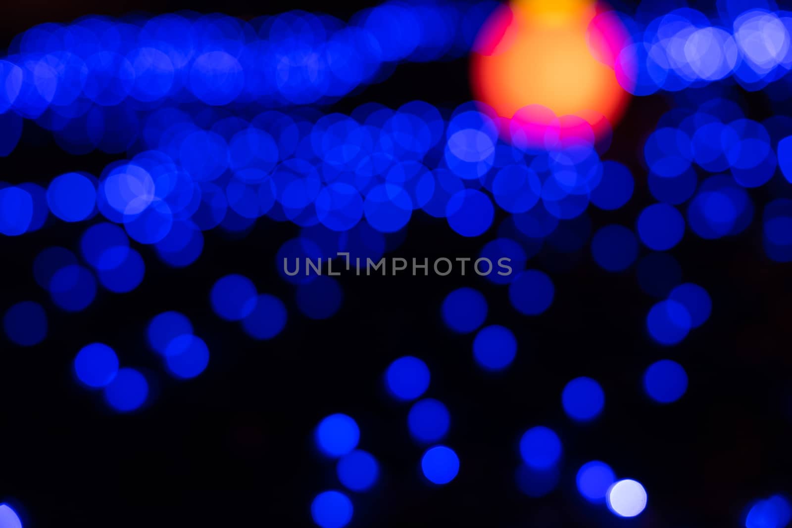 Defocused abstract blue christmas background with orange light