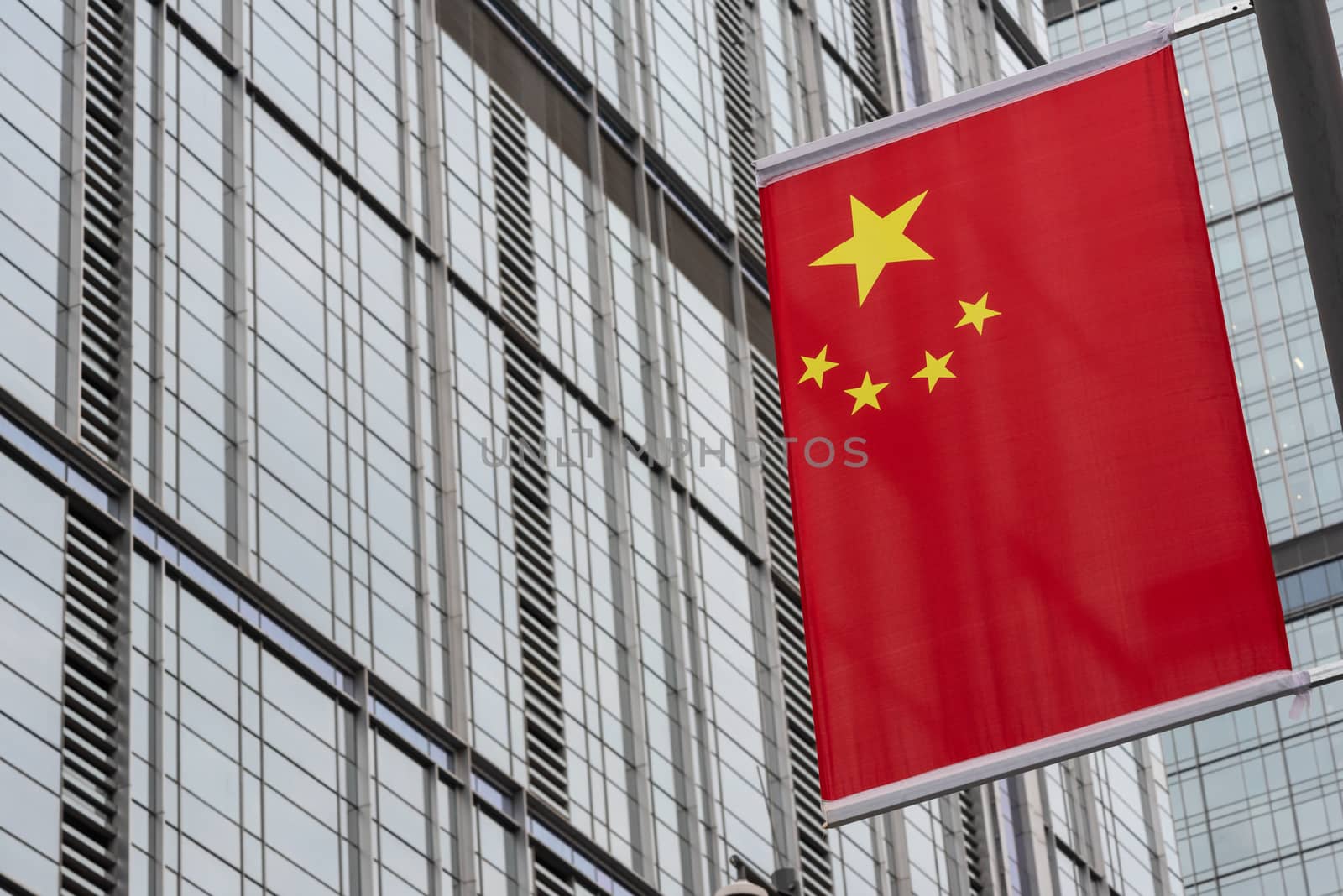 chinese flag close-up view against skyscraper facade