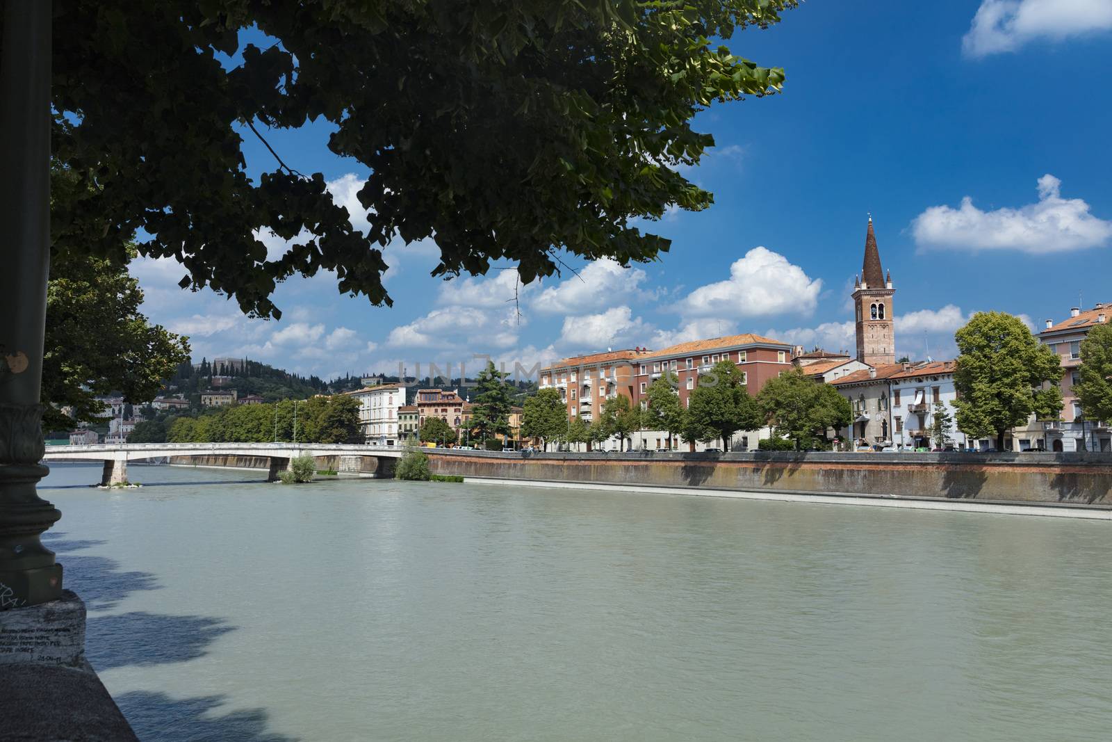 Verona, Italy, Europe, August 2019, view of the River Adige and the tower of the Chiesa Parrocchiale di Santa Maria in Organo