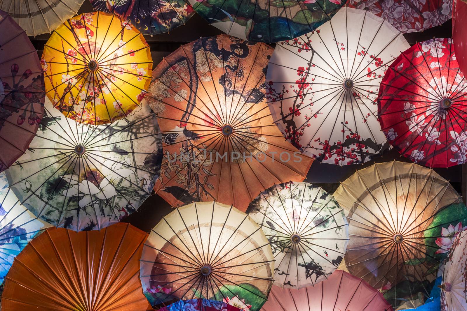 Multi colored chinese umbrellas illuminated at night by LP2Studio