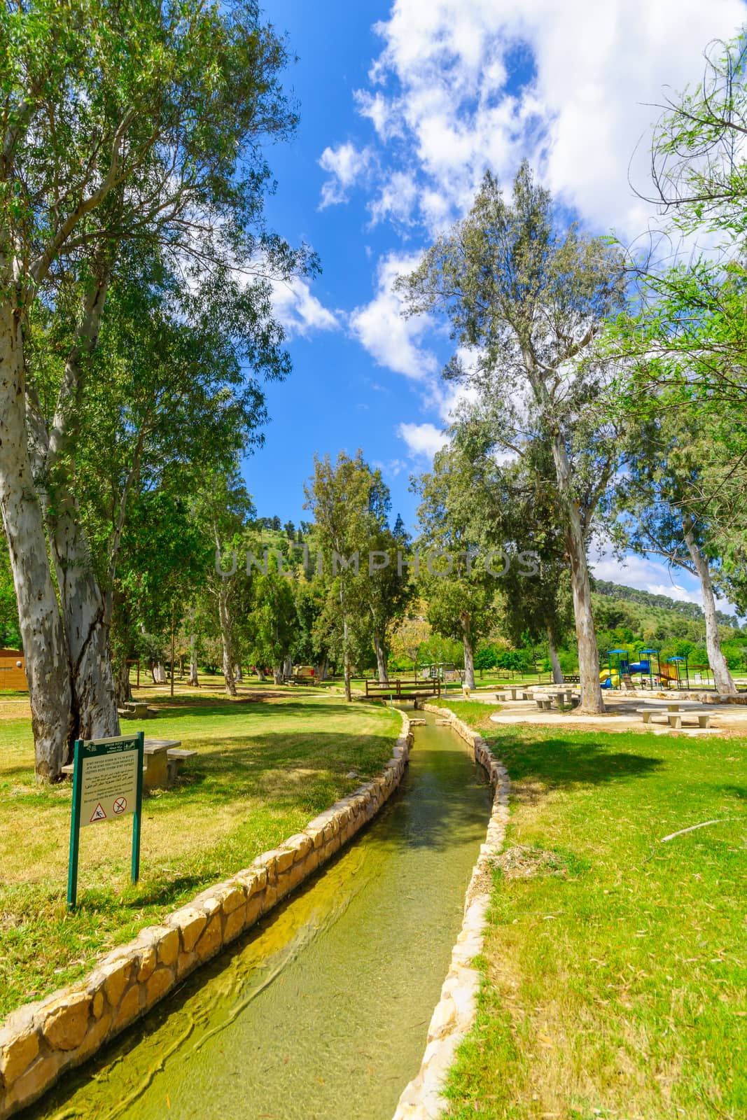 Gideona, Israel - May 06, 2020: View of a picnic area, water canals and trees in Maayan Harod National Park. Northern Israel