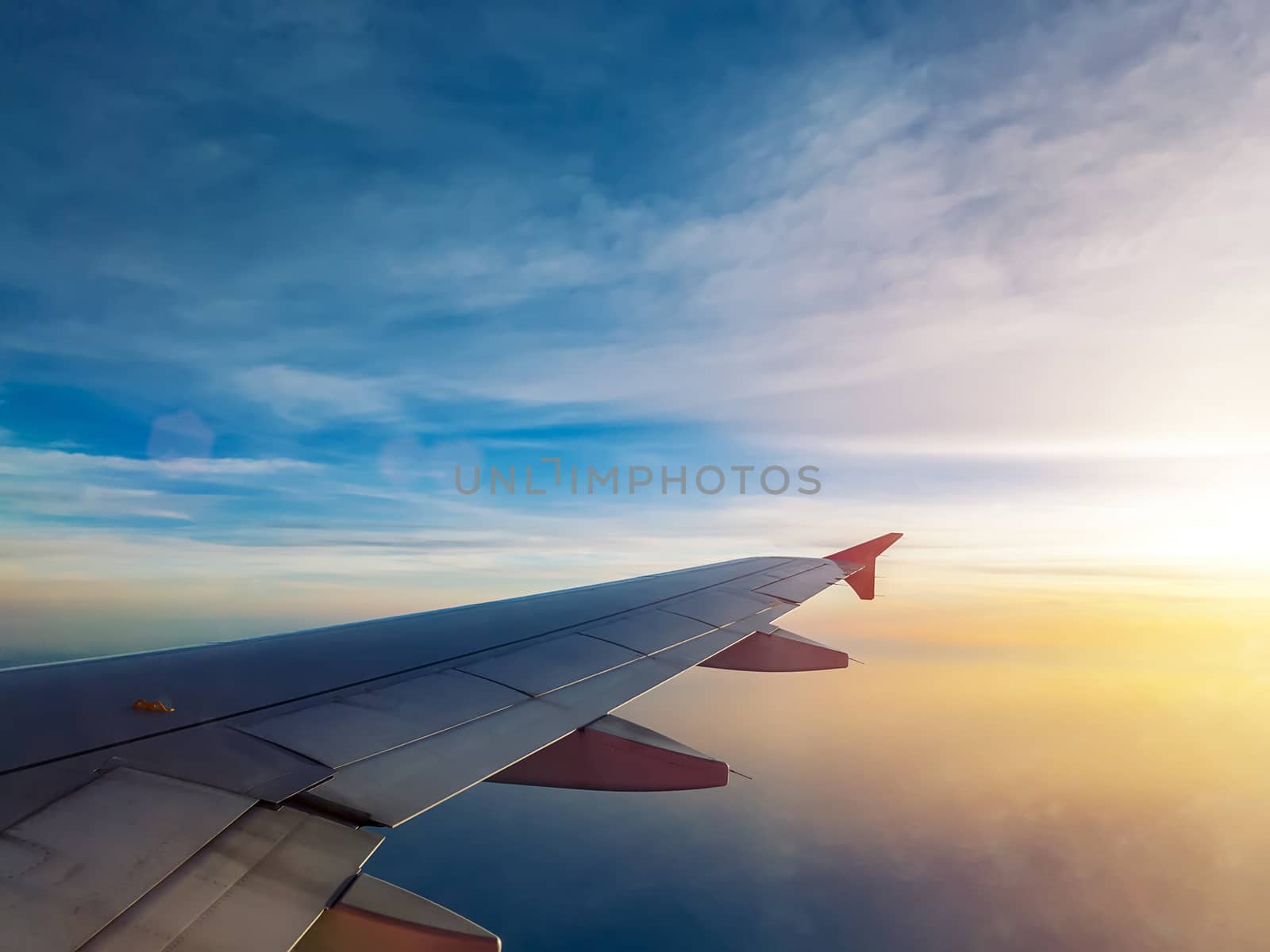 sunset sky as seen through window of airplane, plane window. travel and vacation concept