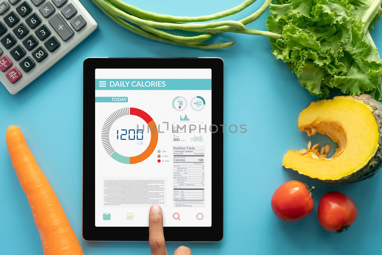 Calories counting , diet , food control and weight loss concept. woman using Calorie counter application on tablet at dining table with fresh vegetable and calculator