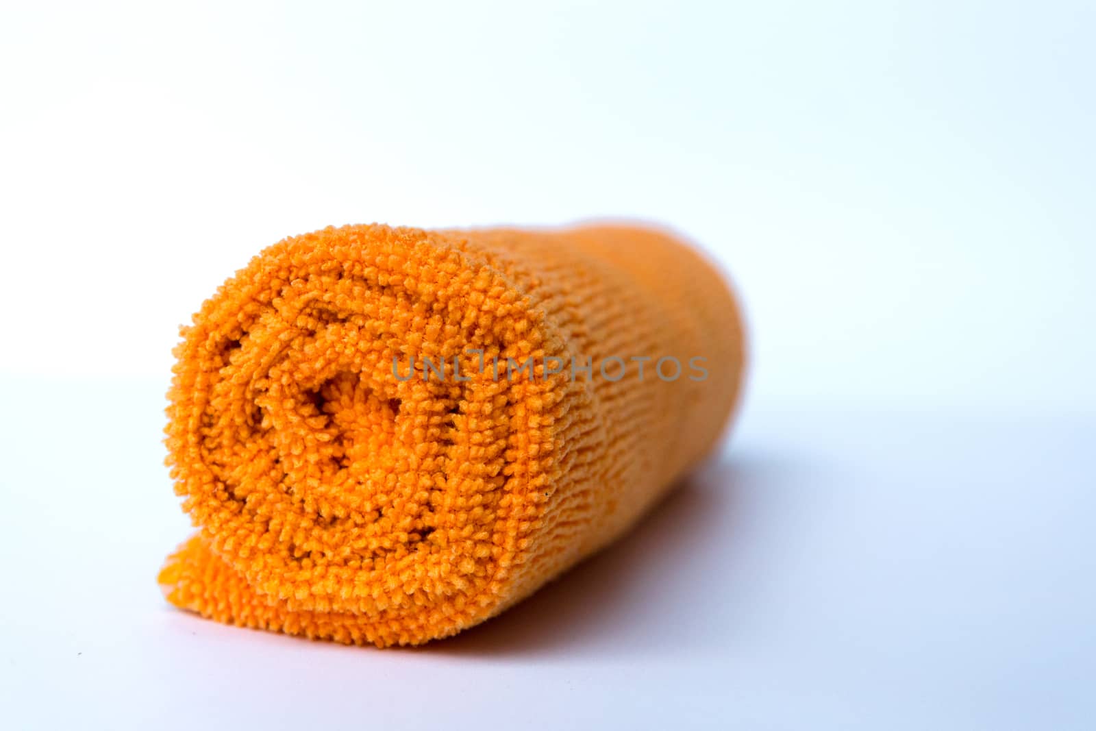 roll orange towel placed on white background