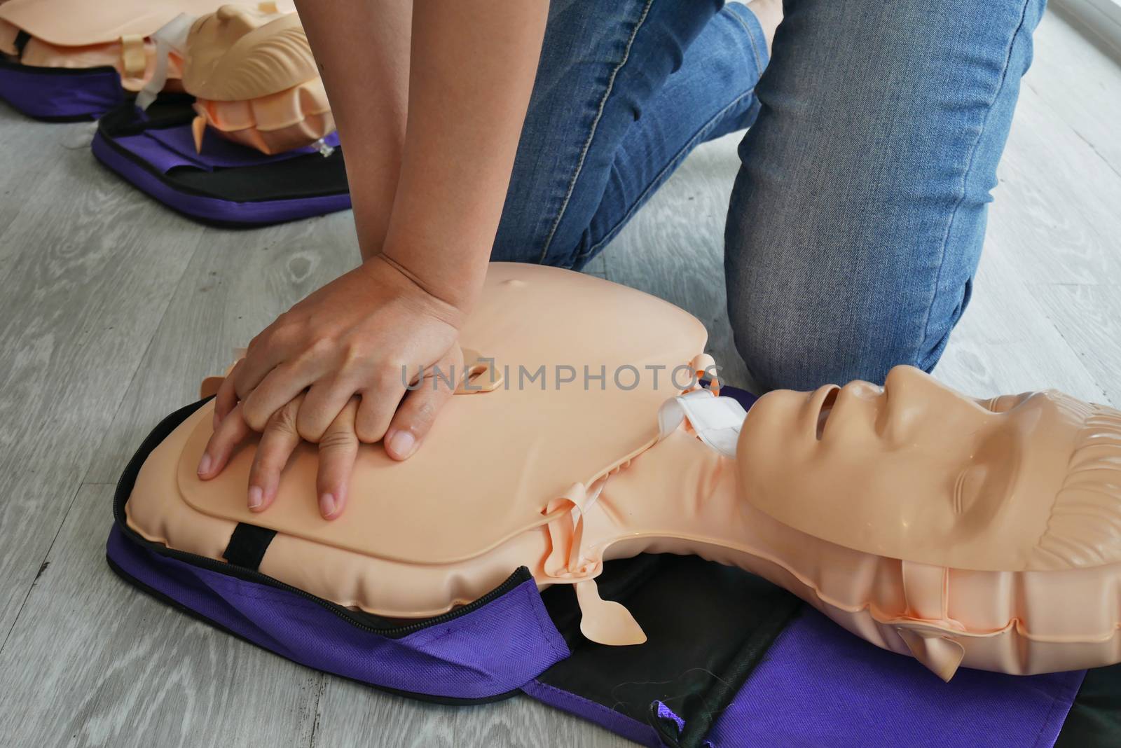 cpr training. close-up of trainee's hand pump on chest of dummy on CPR First Aid Training course for primary safe life by asiandelight