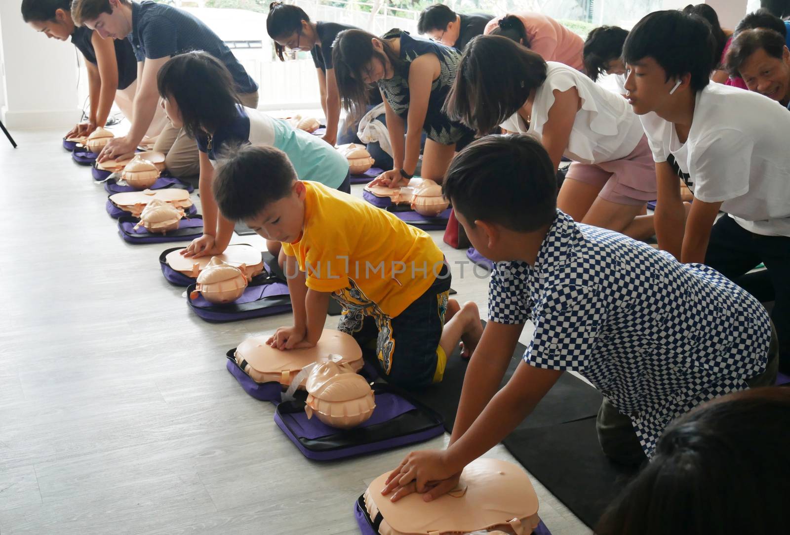 BANGKOK, THAILAND - OCTOBER 6, 2019 : a part of children and adult , participant of CPR First Aid Training course using hand pump on chest of dummy for primary safe life in Bangkok, Thailand on October 6, 2019 by asiandelight
