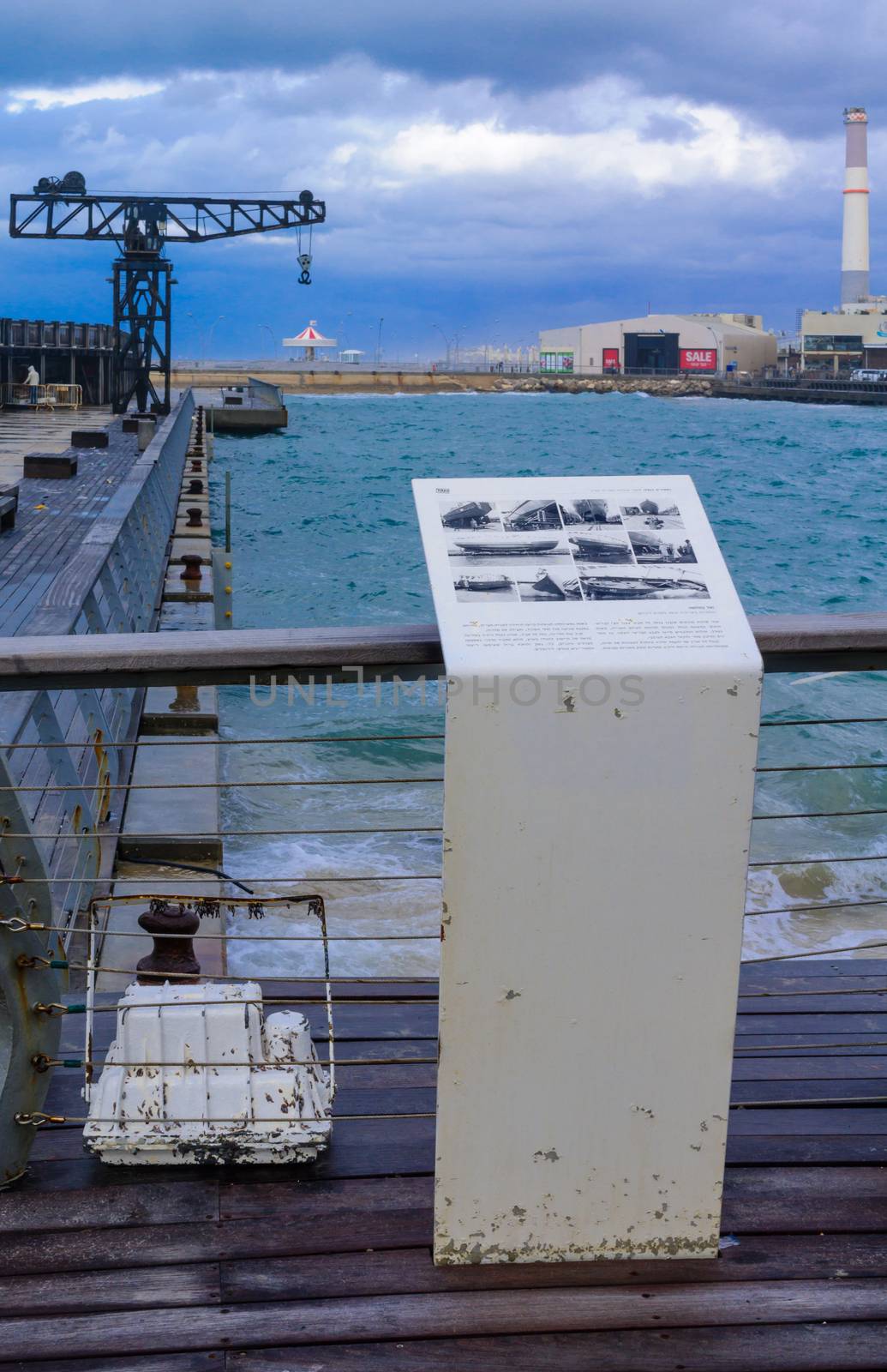 TEL-AVIV - JANUARY 25, 2016: Winter scene with a restored old crane, with restaurants and commercial area in the background, in Tel-Aviv Port, Israel. The port compound was restored as a dining and commercial area