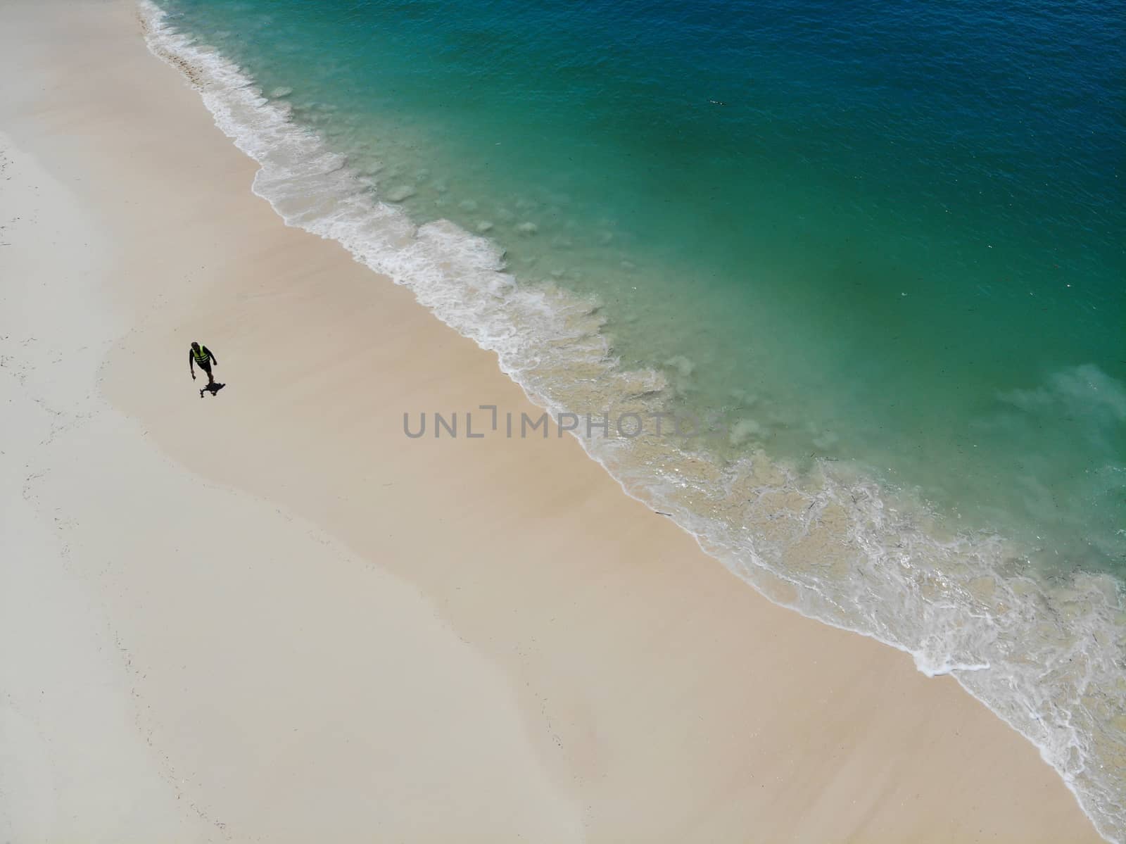 Alone men walk on the beach in summer with sea waves  clear and beautiful color top view by drone