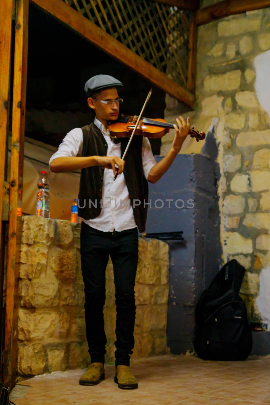 SAFED, ISRAEL - AUGUST 23, 2017: Scene of the Klezmer Festival, with street musician playing, in Safed (Tzfat), Israel. Its the 30th annual traditional Jewish festival in the public streets of Safed