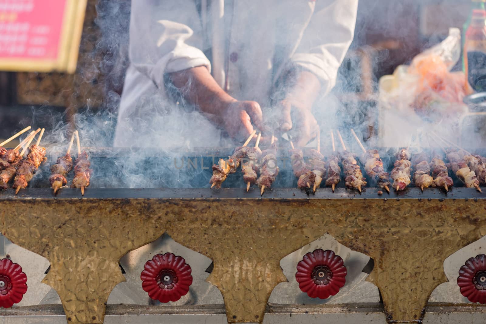 Man cooking skewers on a traditional market in Chengdu, Sichuan province, China