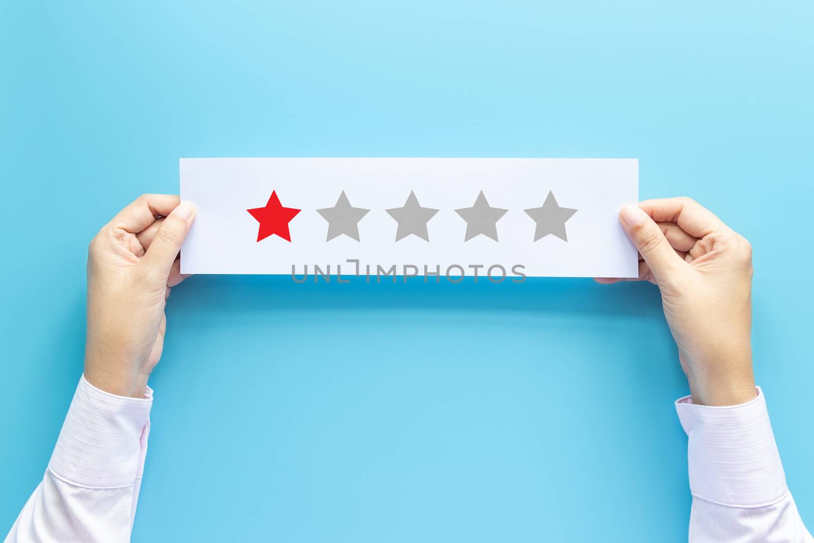 rating and feedback concept. customer holding paper with poor satisfied review by give one star for service experience by asiandelight