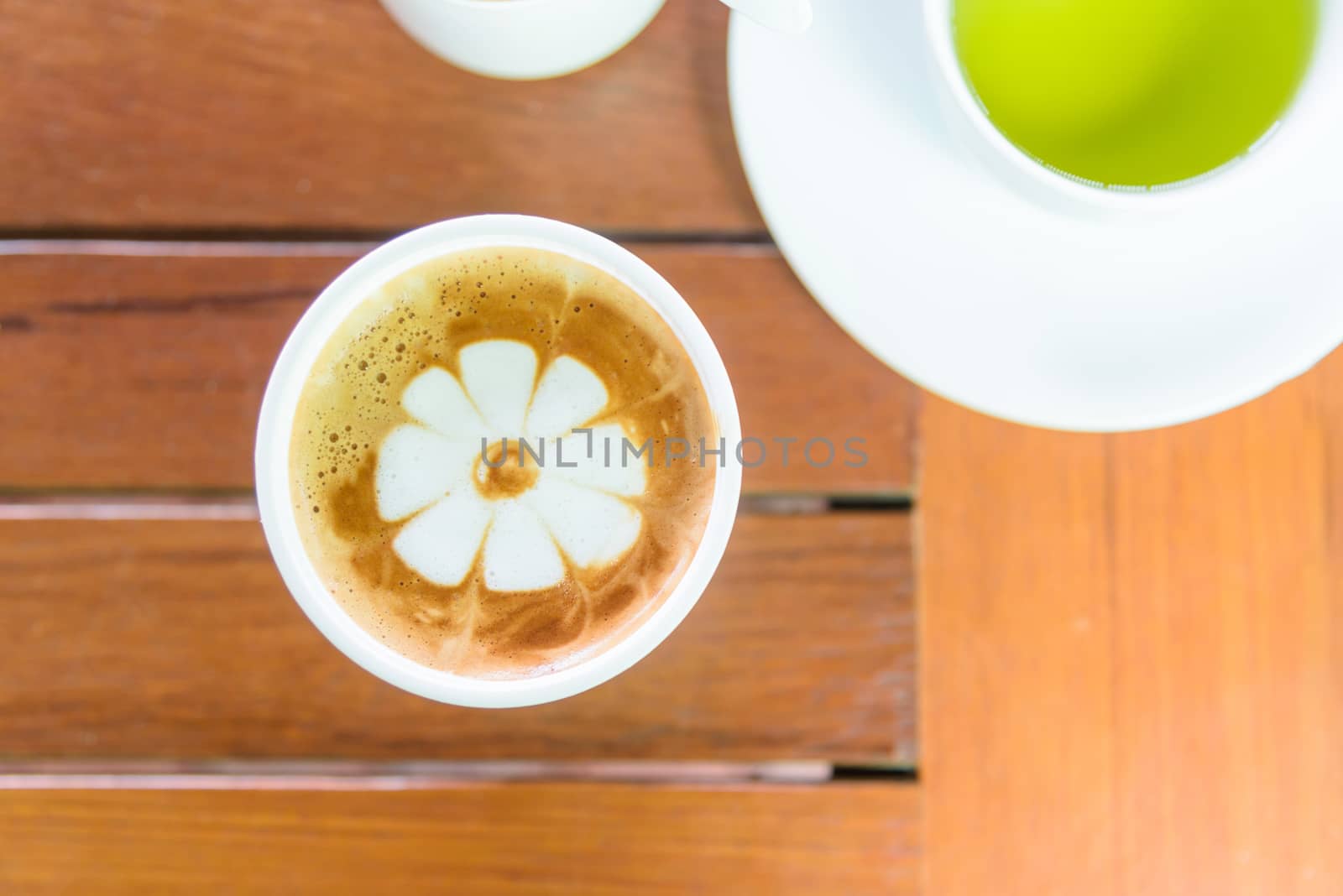 hot cappuccino coffee with nice pattern foam on table by rukawajung