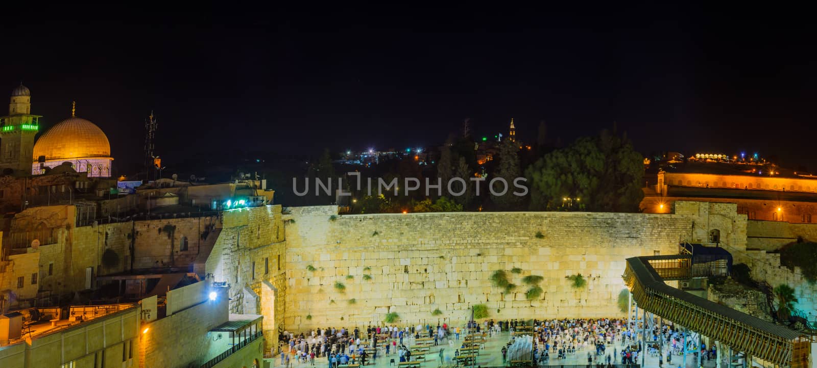JERUSALEM, ISRAEL - SEPTEMBER 06, 2017:  Night scene of the Western Wall with Jewish prayers, and the Dome of the Rock in the background, in Jerusalem, Israel