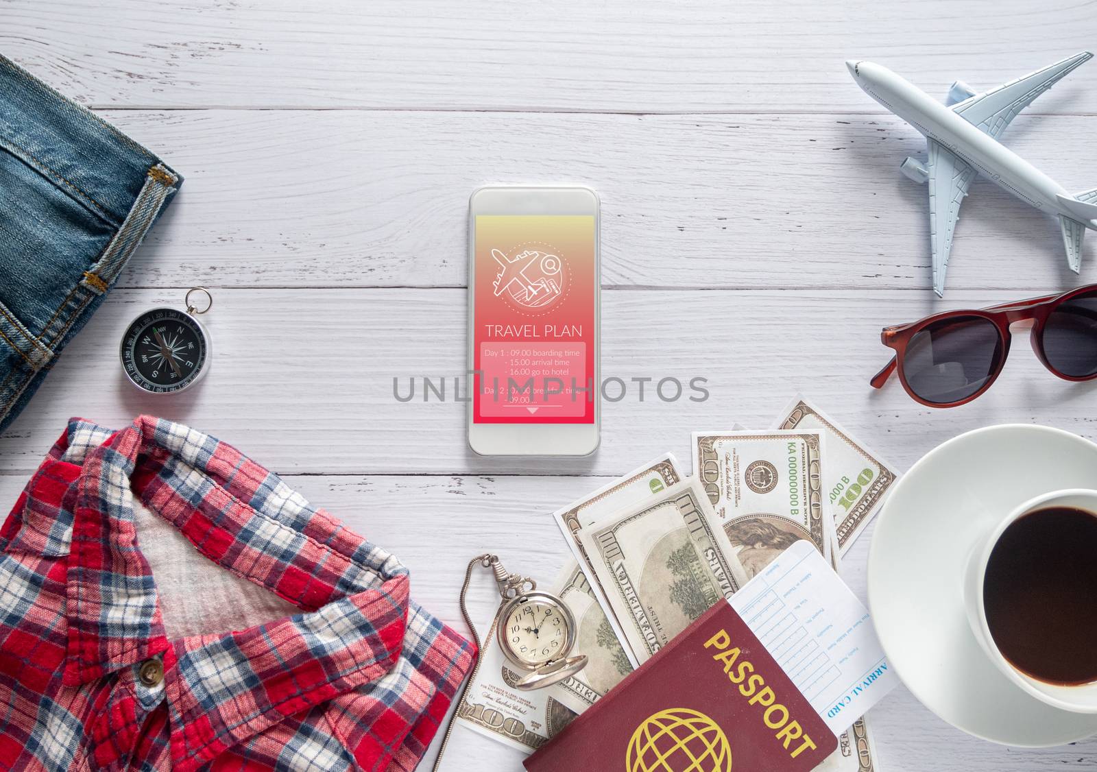 travel plan application technology concept. travel itinerary program list on application on smart phone with travel item accessory, clothes , passport and money on white table by asiandelight