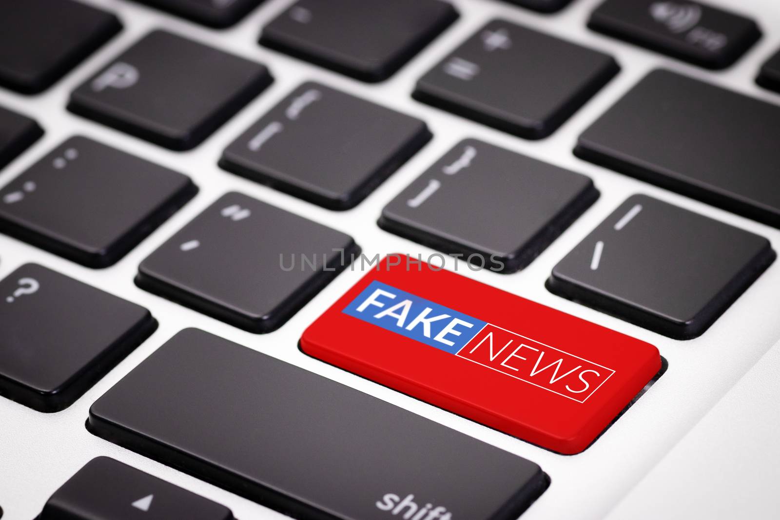 red fake news button on laptop keyboard. fake news on internet in modern digital age concept by asiandelight