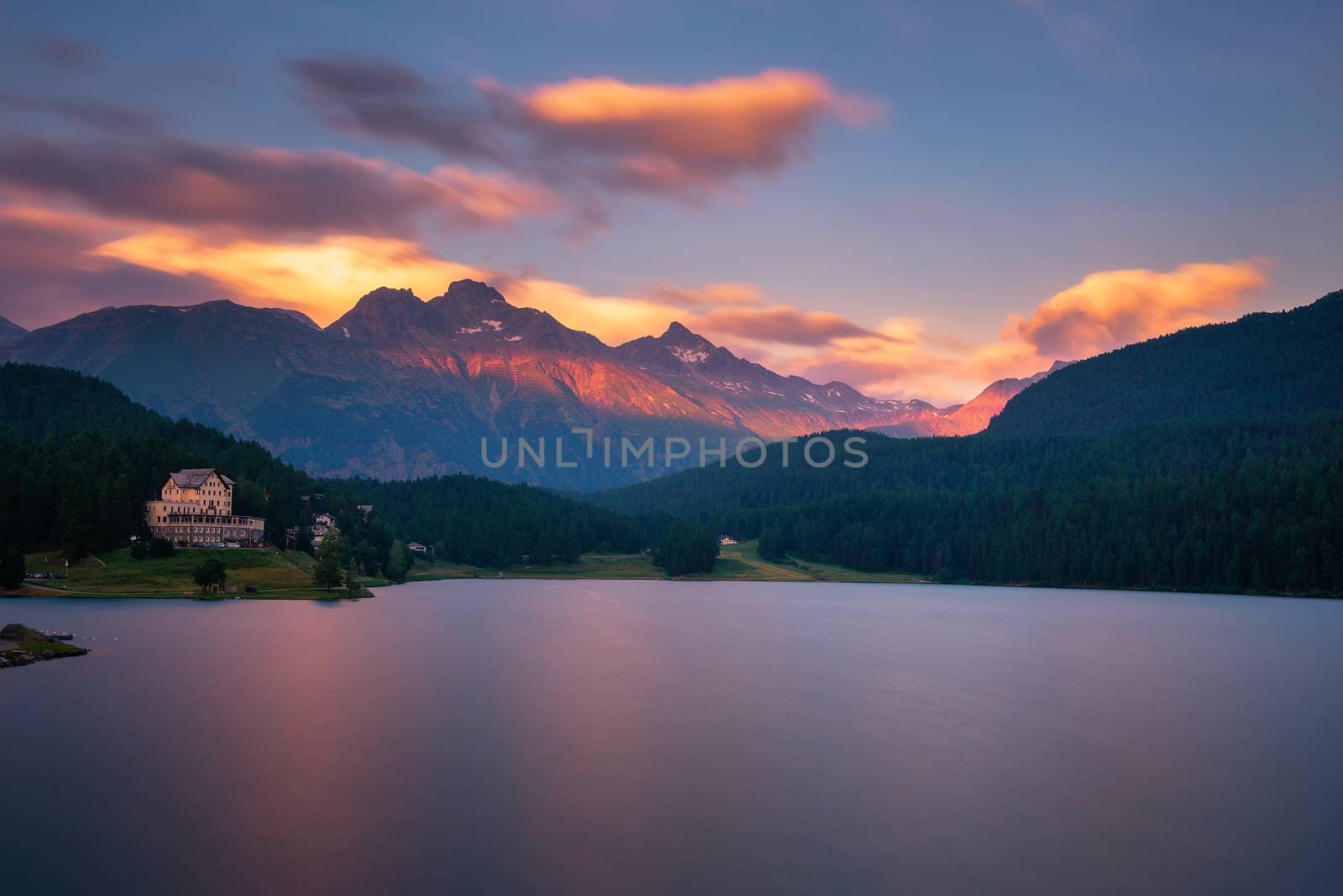 Sunset above lake St. Moritzersee with Swiss Alps and a mountain hotel by nickfox