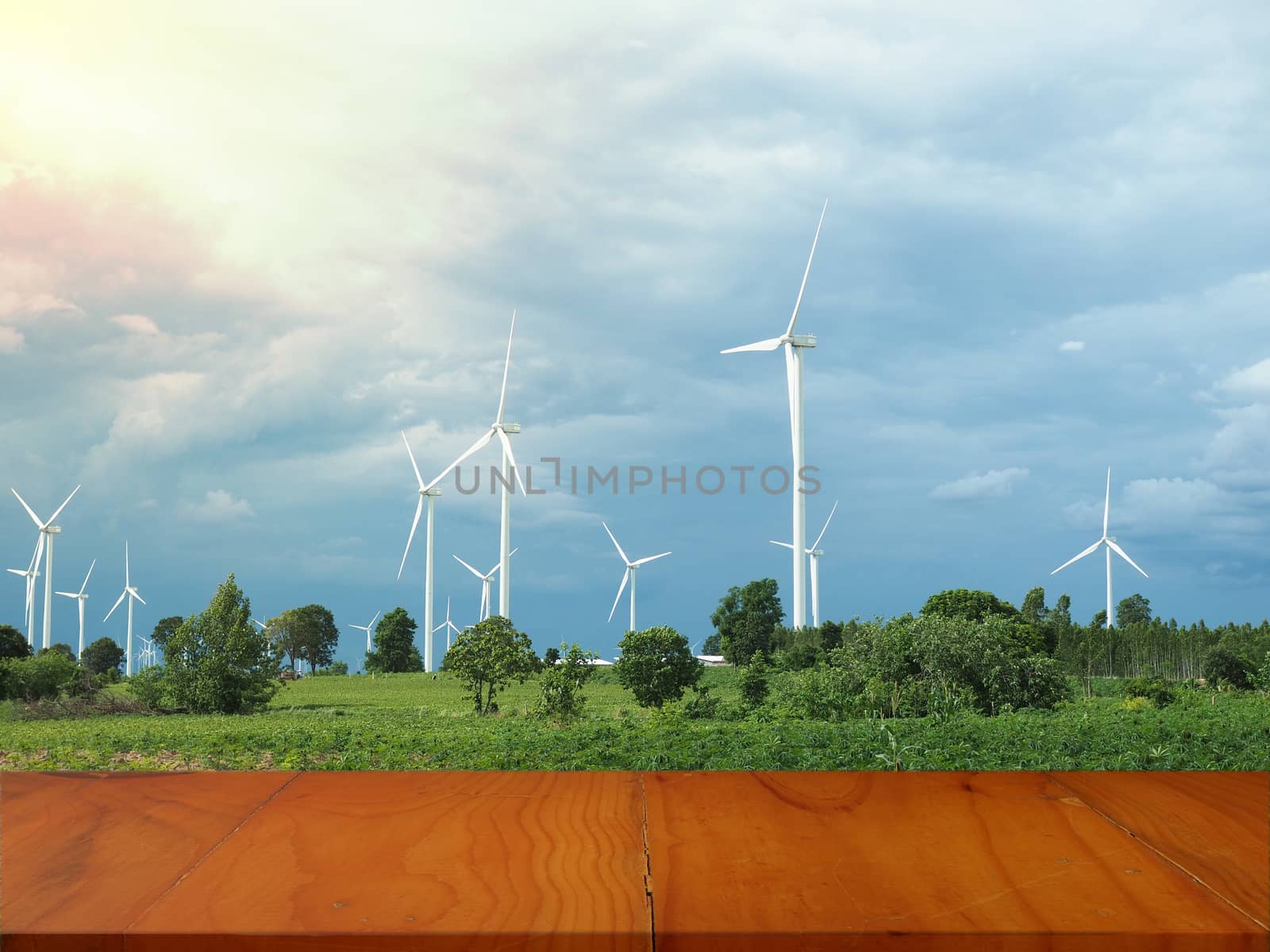 Empty wooden table with Wind turbine background.