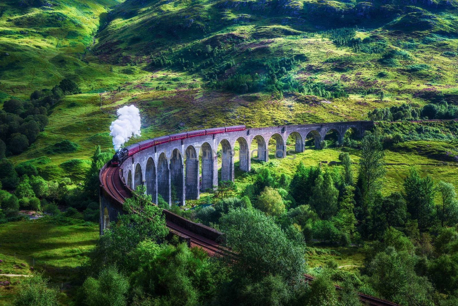 Glenfinnan Railway Viaduct in Scotland with the Jacobite steam train passing over. Artistic vintage style processing.