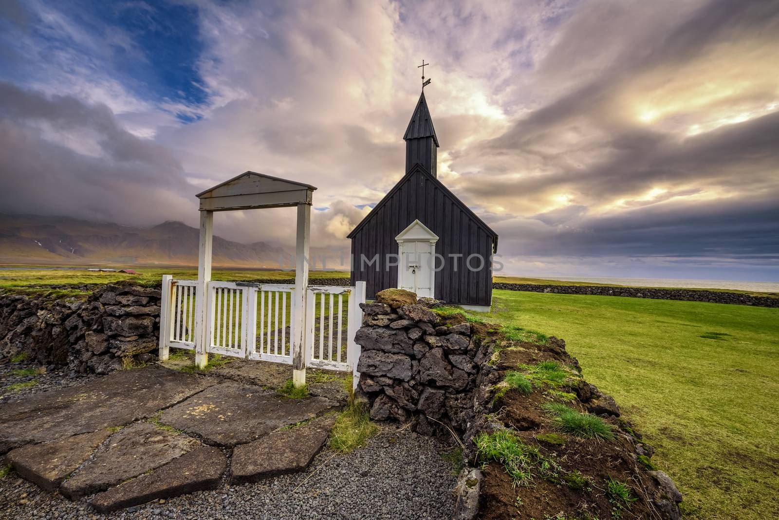 Entry gate and black wooden church of Budir in Iceland