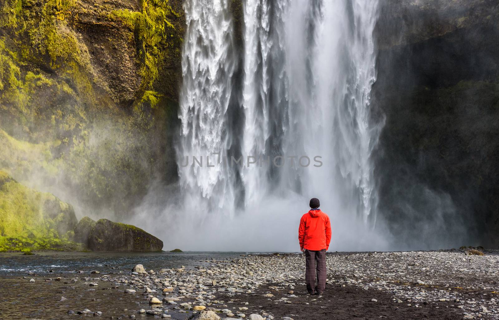 Tourist looking at the famous Skogafoss waterfall in southern Iceland