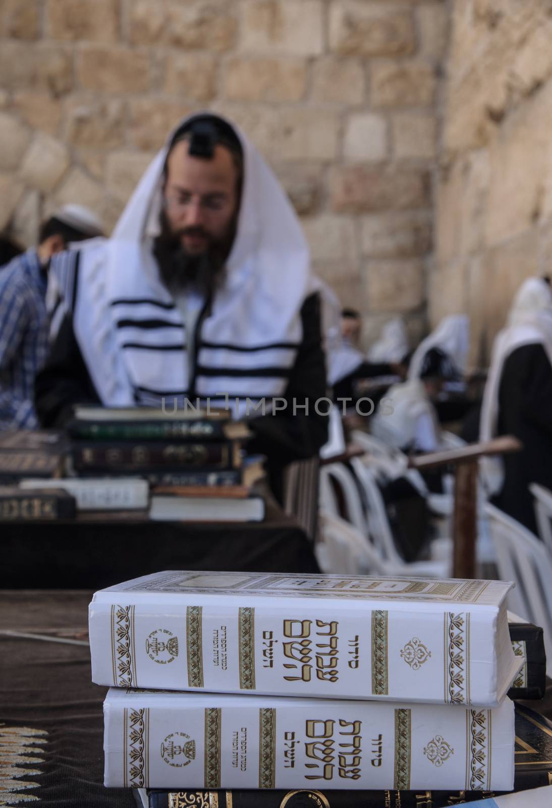 JERUSALEM - JULY 31 - Orthodox Jews prays at the Western Wall, behind praying book (Siddur) - July 31, 2013 in the old city of Jerusalem, Israel. This is the holiest place in Jewish tradition