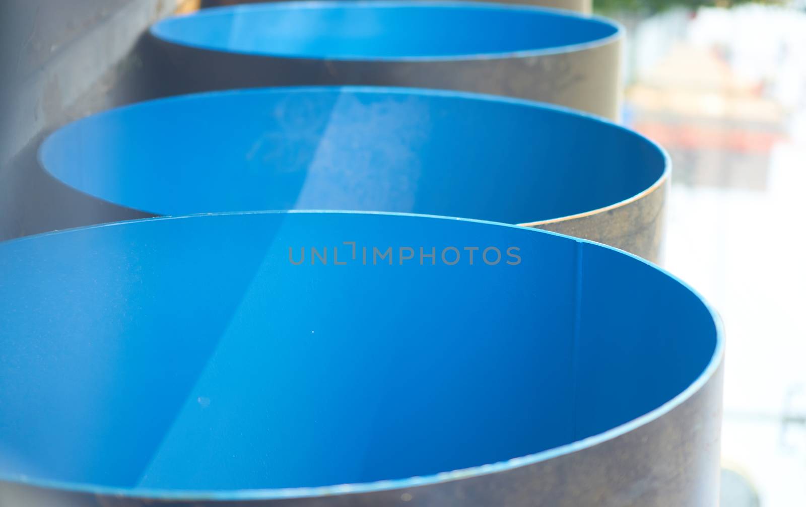 blue construction big pipe before install with sun flare ,vertical