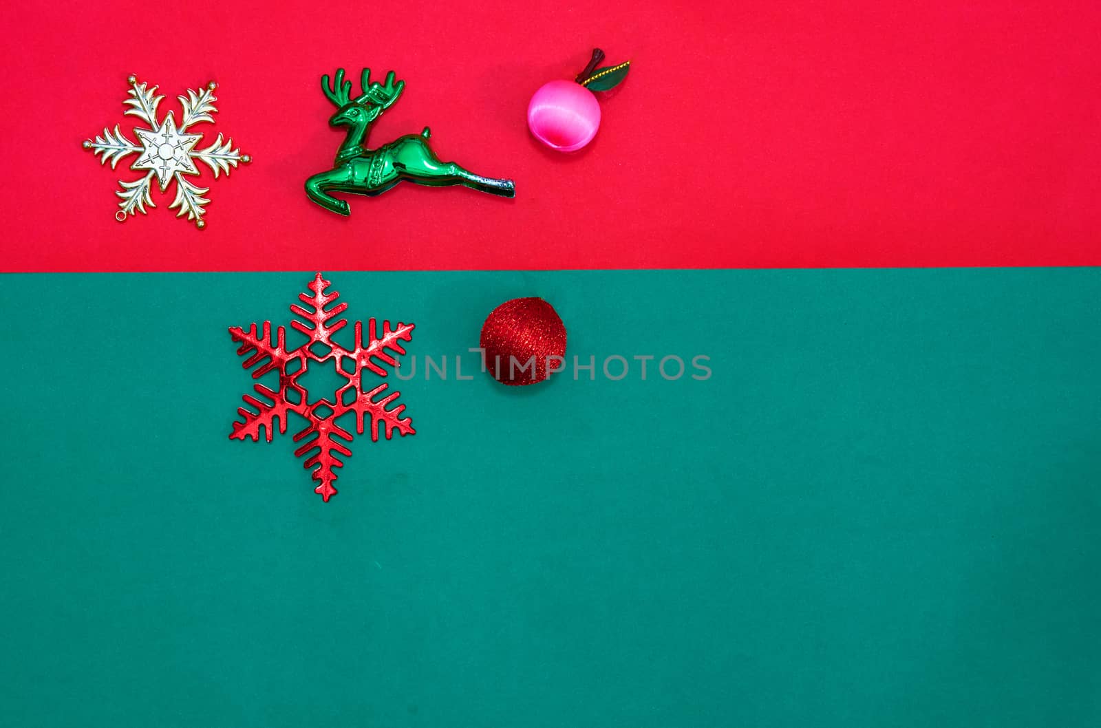 Christmas bauble,snow flake ,presents ,reindeer and leaves on Red green background with snow fall,top  view with copy space