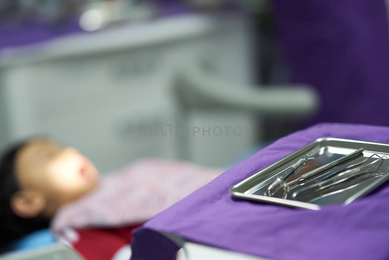 Dentist tools on tray on patient blur background