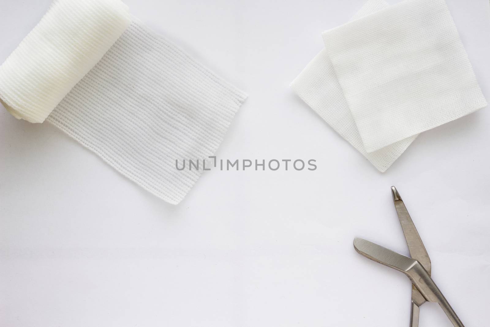 Gauzes, scissors and roll gauze on white background,top view