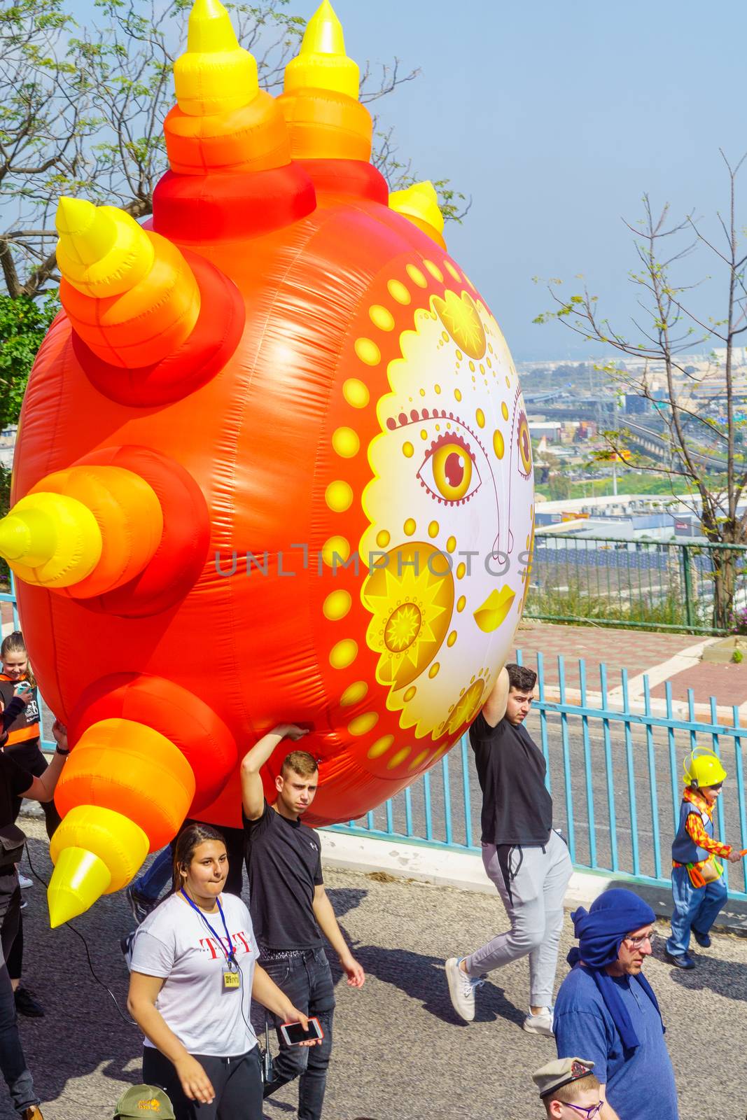 Nesher, Israel - March 22, 2019: People, some in costumes, celebrate the Jewish holyday of Purim in the Adloyada parade, in Nesher, Israel