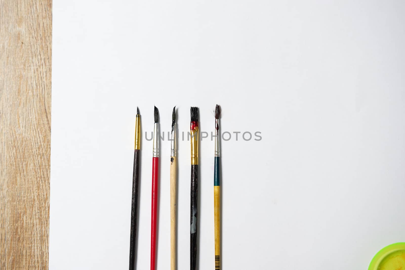Paper of art work with part of  plate and color brushes