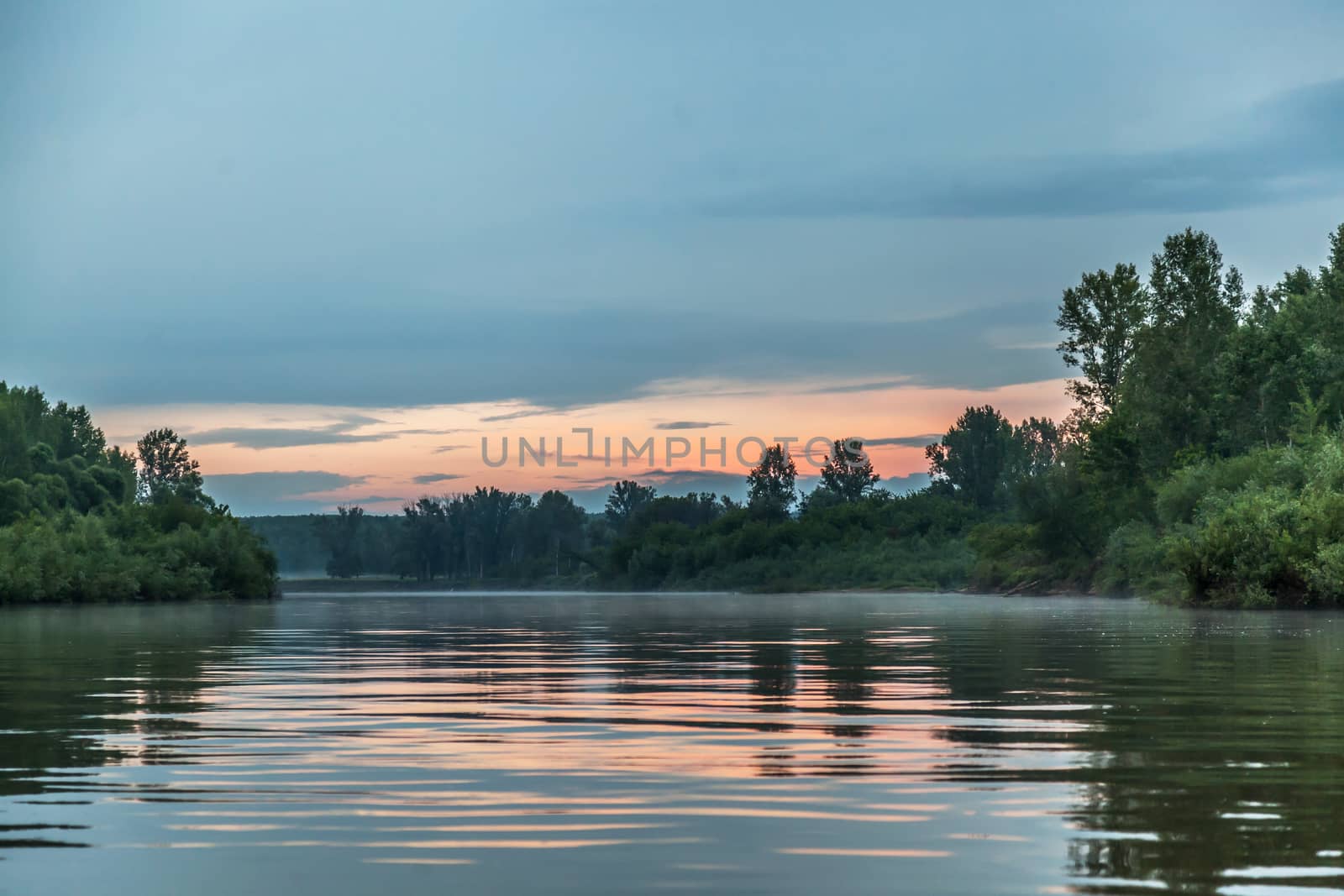 Beautiful pink sunset over the river and forest